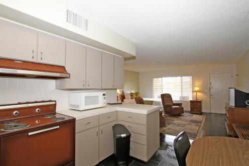 uma cozinha com armários brancos e uma sala de estar em Lido Palms Resort & Spa em Desert Hot Springs