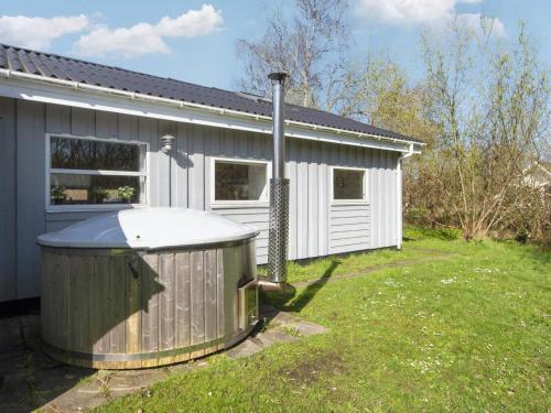 uma casa com uma banheira de hidromassagem no quintal em 8 person holiday home in Ebeltoft em Ebeltoft