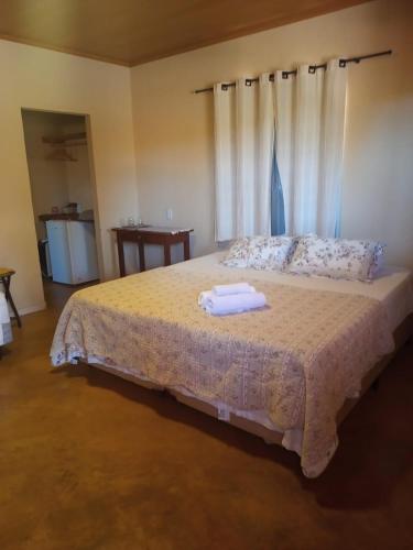 een slaapkamer met een bed met twee handdoeken erop bij viladasararas in Alto Paraíso de Goiás