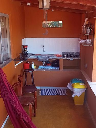 een keuken met een aanrecht en een aantal stoelen in een kamer bij viladasararas in Alto Paraíso de Goiás