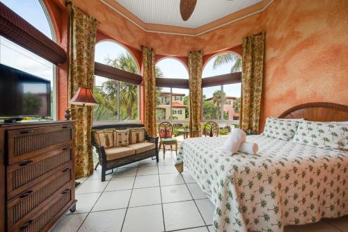 1 dormitorio con 1 cama, TV y ventanas en Villa Maria - Holmes Beach, FL en Holmes Beach