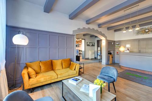 un salon avec un canapé et une table dans l'établissement Brit Hotel Roanne - Le Grand Hôtel, à Roanne