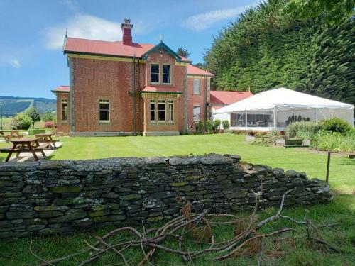 a brick house with a stone wall in a yard at Mainholm in Gore