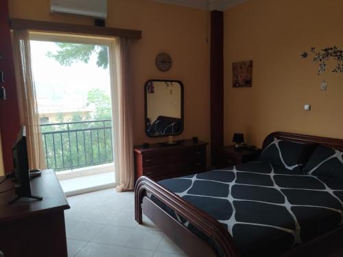 sypialnia z łóżkiem, lustrem i oknem w obiekcie Vens apartment 90m2 at Eantio bay. w mieście Aiándion
