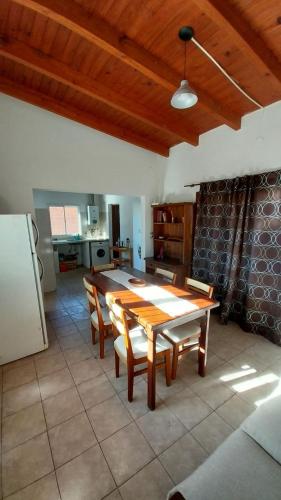 cocina con mesa de madera, sillas y nevera en La casa del árbol en San Salvador de Jujuy