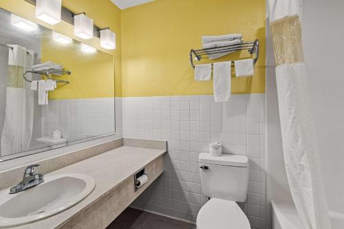 a bathroom with a sink and a toilet and a mirror at Americas Best Value Inn Carlisle in Carlisle
