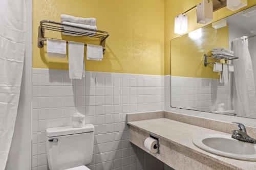 a bathroom with a toilet and a sink and a mirror at Americas Best Value Inn Carlisle in Carlisle