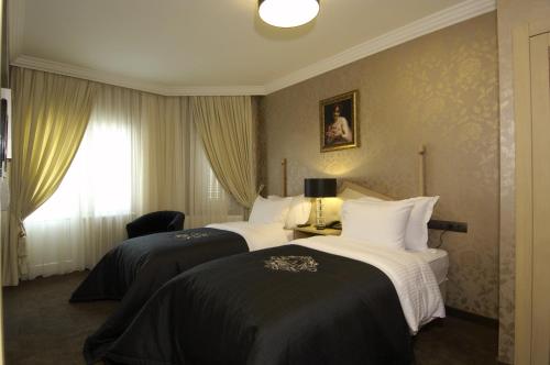 een hotelkamer met 2 bedden met zwart-witte lakens bij Ada Life Hotel in Eskisehir