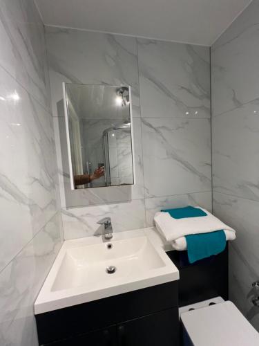a white bathroom with a sink and a toilet at Leicester Oadby 4 bed home, 8 guests, park 5 cars in Oadby