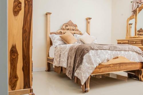 een slaapkamer met een bed met een houten hoofdeinde bij Christal Sunshine in Boca Pen