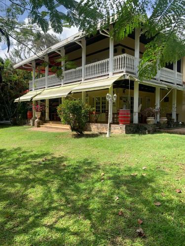 a large house with a lawn in front of it at Between us : Chambres d’hôtes à Saint joseph in Saint-Joseph