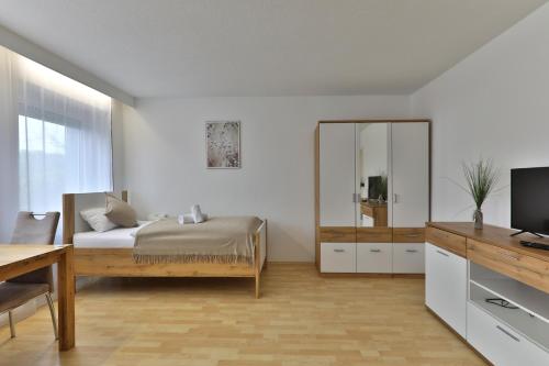a bedroom with a bed and a mirror and a desk at Moderne Ferienwohnungen - Service wie im Hotel in Göppingen