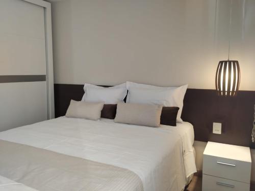 ein Schlafzimmer mit einem großen weißen Bett mit weißen Kissen in der Unterkunft UH 1116 Flat Live Logde Vila Mariana in São Paulo