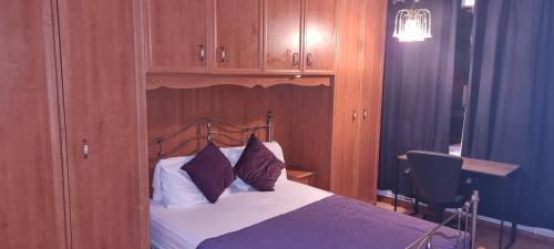 a bedroom with a bed with a wooden headboard at Fleetway Private Rooms in London