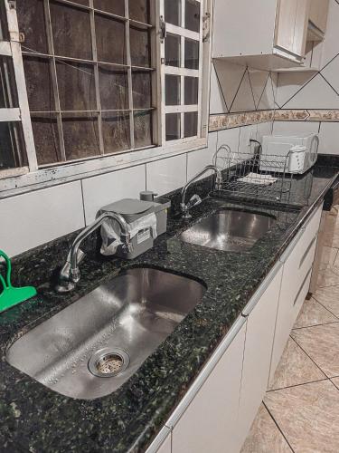 a kitchen with a sink and a counter top at Hostel Network - Faça Novas Conexões, Desfrute de Qualidade e Privacidade in Anápolis