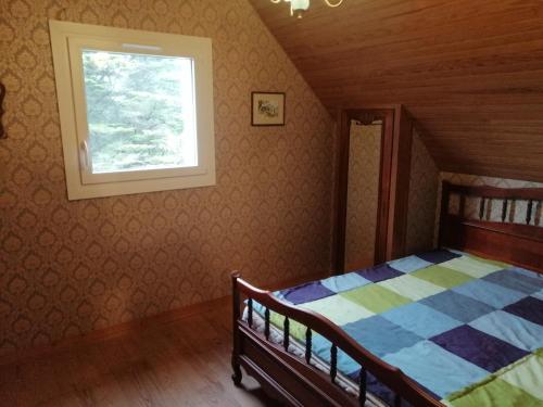 Schlafzimmer mit einem Bett und einem Fenster in der Unterkunft Ker Loïc, Les Dunes, La Mer in Saint-Pabu