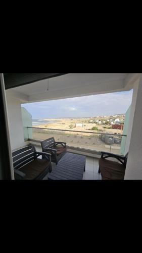 a room with chairs and a view of a beach at Appartement de haut standing in Tama ou Ennza