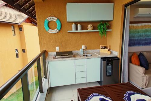 a kitchen in a tiny house with a balcony at Apartamento EcoResort Carneiros in Praia dos Carneiros