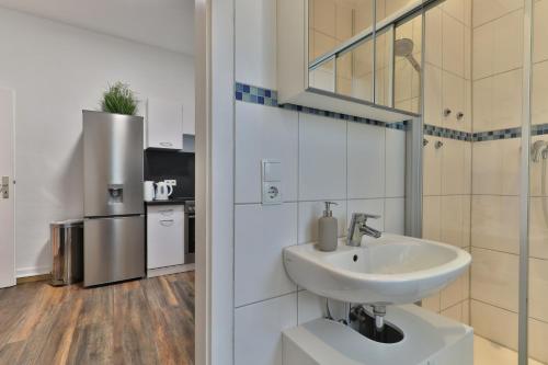 y baño blanco con lavabo y ducha. en Studio Suite mit Service wie im Hotel, en Göppingen