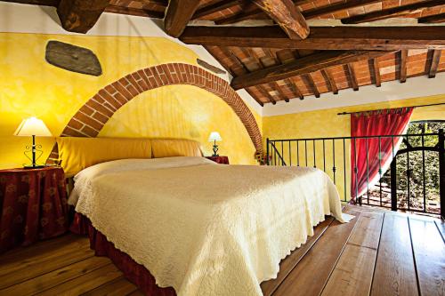 a bedroom with a large bed and a window at Fonte Del Castagno in Sinalunga