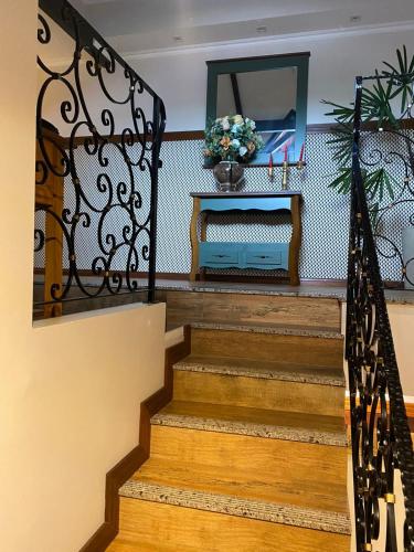a staircase with a wrought iron railing and a mirror at Edelweiss Pomerode in Pomerode