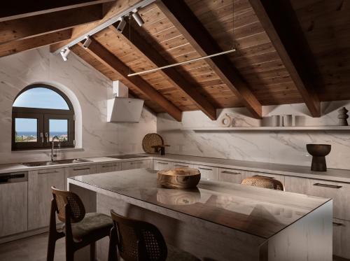 Vis di Vardi Luxury Estate في مدينة زاكينثوس: مطبخ مع جزيرة رخام كبيرة في الغرفة