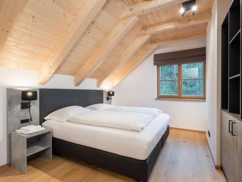 a bedroom with a large bed and wooden ceilings at Schletski in Donnersbachwald