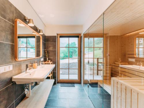 a bathroom with two sinks and a large window at Chalet Norah in Donnersbachwald