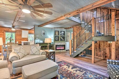 a living room with a couch and a staircase at Secluded Table Rock LakeandBranson Cabin with Hot Tub! in Kimberling City