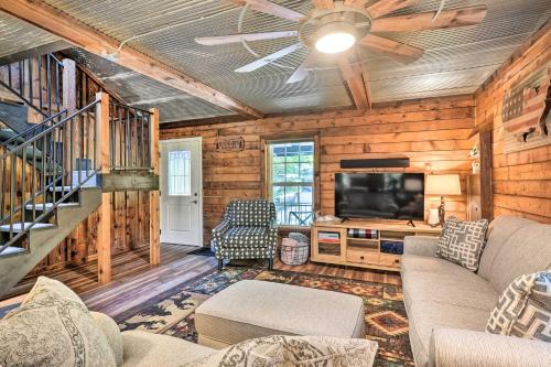a living room with a couch and a tv at Secluded Table Rock LakeandBranson Cabin with Hot Tub! in Kimberling City