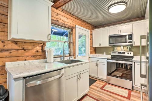 a kitchen with white cabinets and a stove top oven at Secluded Table Rock LakeandBranson Cabin with Hot Tub! in Kimberling City