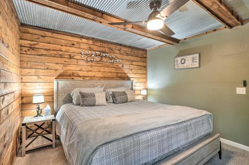 1 dormitorio con 1 cama y pared de madera en Secluded Table Rock LakeandBranson Cabin with Hot Tub!, en Kimberling City