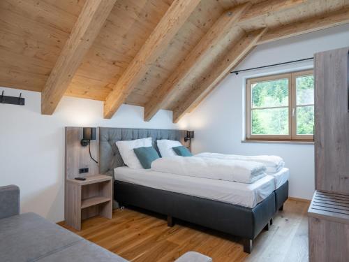 two beds in a room with wooden ceilings at Haus Elau in Donnersbachwald