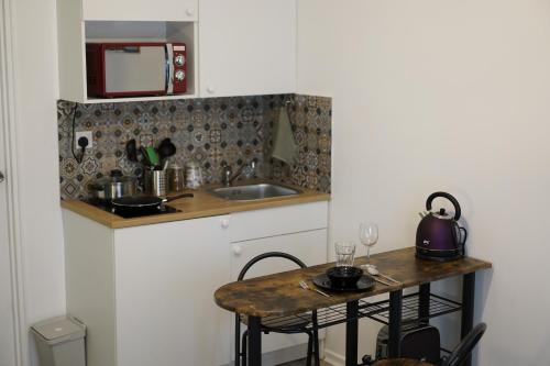 Exquisite Studio #4 في لندن: مطبخ صغير مع طاولة ومغسلة