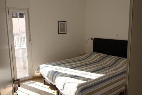 un letto in una stanza bianca con una finestra di Pinna Nobilis MoMa level 1 a Brodarica