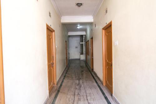 um corredor vazio com pisos e portas de madeira em SPOT ON Hotel Sagar em Deoghar