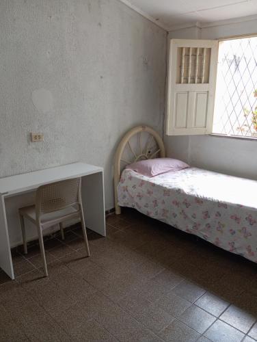 um quarto com uma cama, uma secretária e uma janela em Hostel Teresina em Teresina
