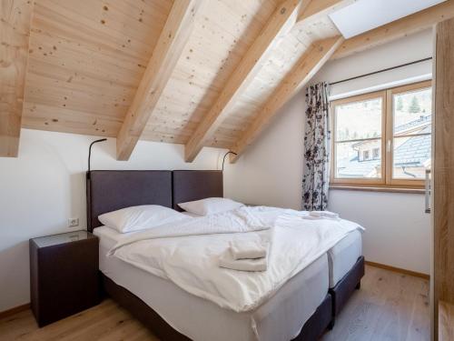 Un dormitorio con una cama grande en una habitación con techos de madera. en Haus Lilyan en Donnersbachwald