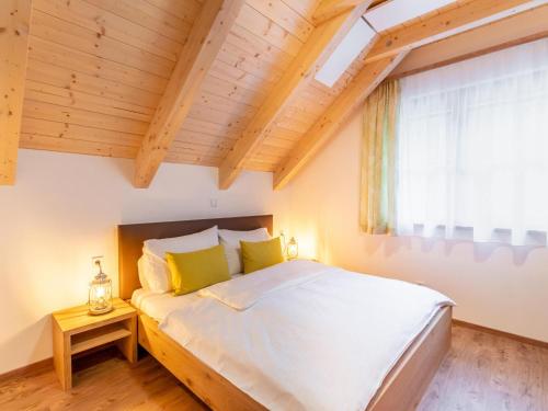 a bedroom with a large white bed with a window at Chalet Thor in Donnersbachwald