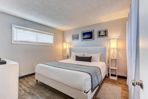 a bedroom with a white bed and a window at 0510 Beachtrippin' home in Carolina Beach