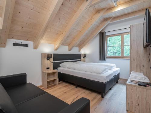 um quarto com uma cama grande e um sofá em Villa Petra em Donnersbachwald