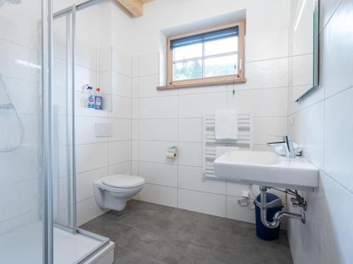 a white bathroom with a sink and a toilet at Villa Petra in Donnersbachwald