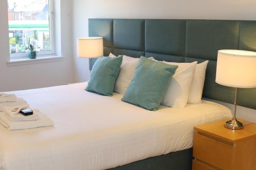 a bedroom with a large white bed with two lamps at Edinburgh Aparthotel in Edinburgh