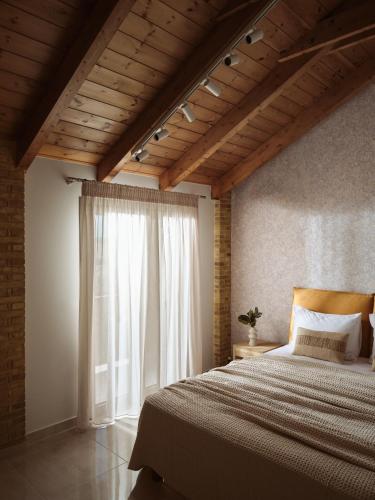 a bedroom with a large bed and a window at Vis di Vardi Luxury Estate in Zakynthos Town