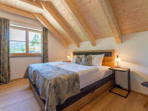 a bedroom with a large bed and a large window at Apart Heidi in Donnersbachwald