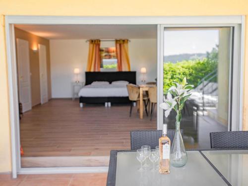 a bedroom with a bed and a table with a bottle of wine at La Parure in Vidauban