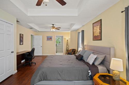 a bedroom with a bed and a ceiling fan at Bamboo Oasis-Relaxing Hot Tub-Family Time in San Antonio