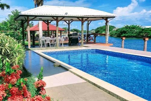 uma piscina com um gazebo junto à água em Waterfront Sunset Apartment in Fantasy Island Nadi em Nadi