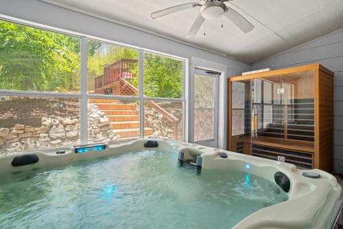 a large bath tub in a room with a large window at Bamboo Oasis-Relaxing Hot Tub-Family Time in San Antonio