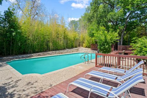 a pool with lounge chairs next to a wooden deck at Bamboo Oasis-Relaxing Hot Tub-Family Time in San Antonio